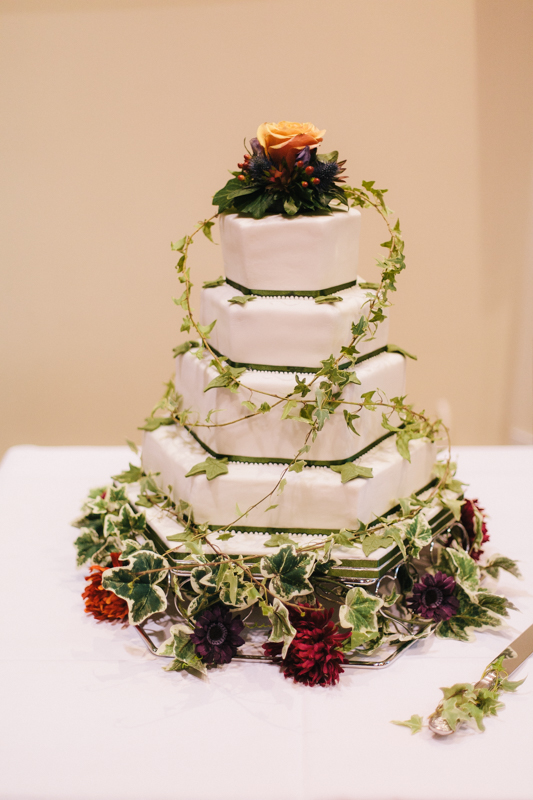 Close-up of autumn wedding cake topped with dried flowers and berries