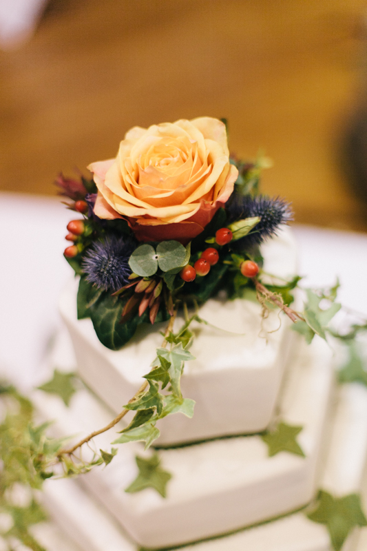 Close-up of autumn wedding cake topped with dried flowers and berries