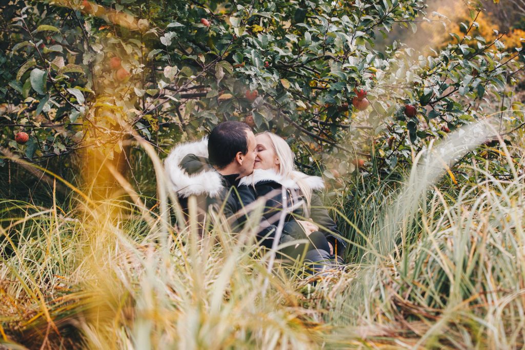 Couple together in a forest path lined with colourful leaves – natural autumn wedding photography