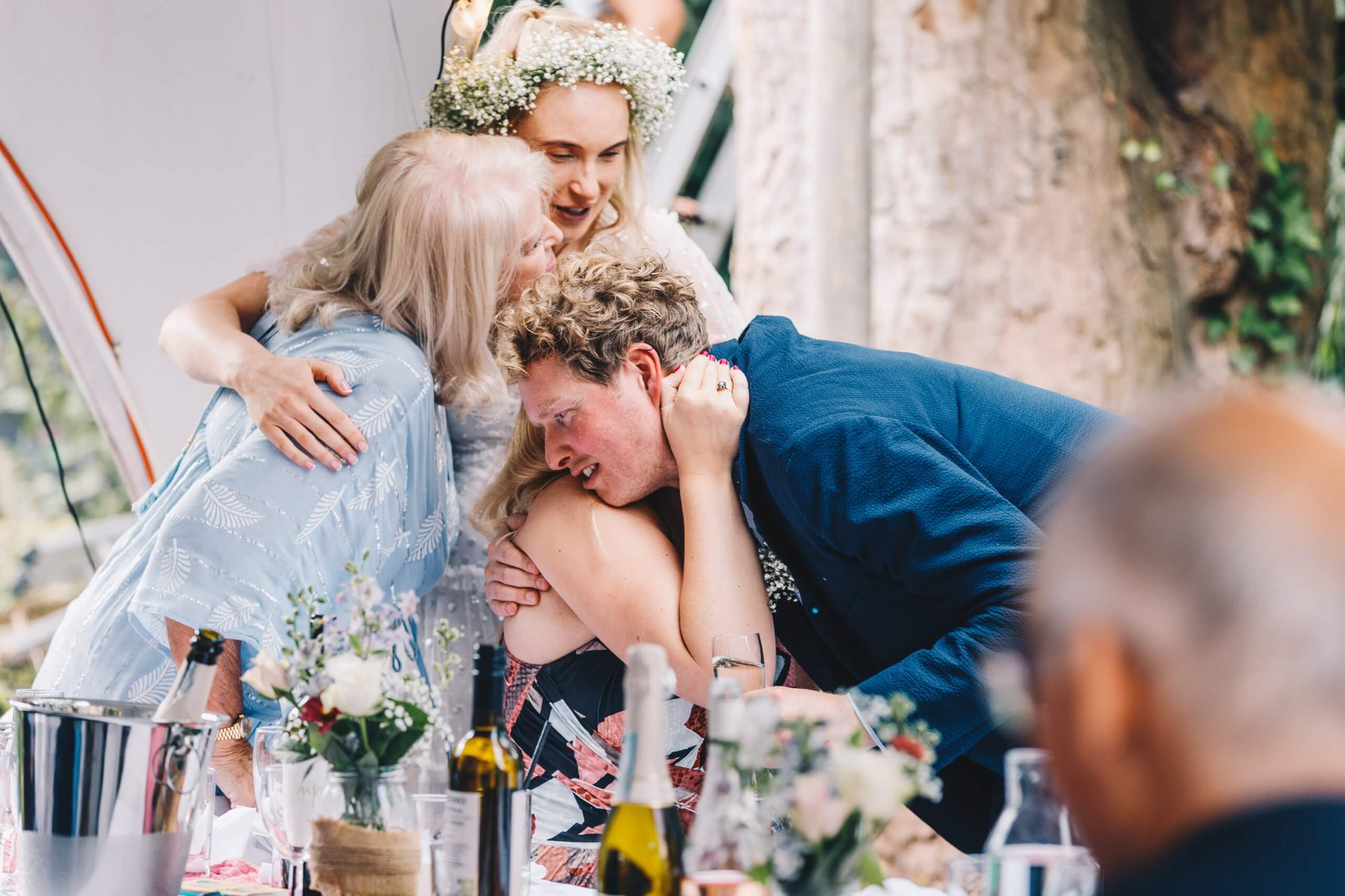 When Should I Book My Wedding Photographer? blog post married couple and family in huge hug