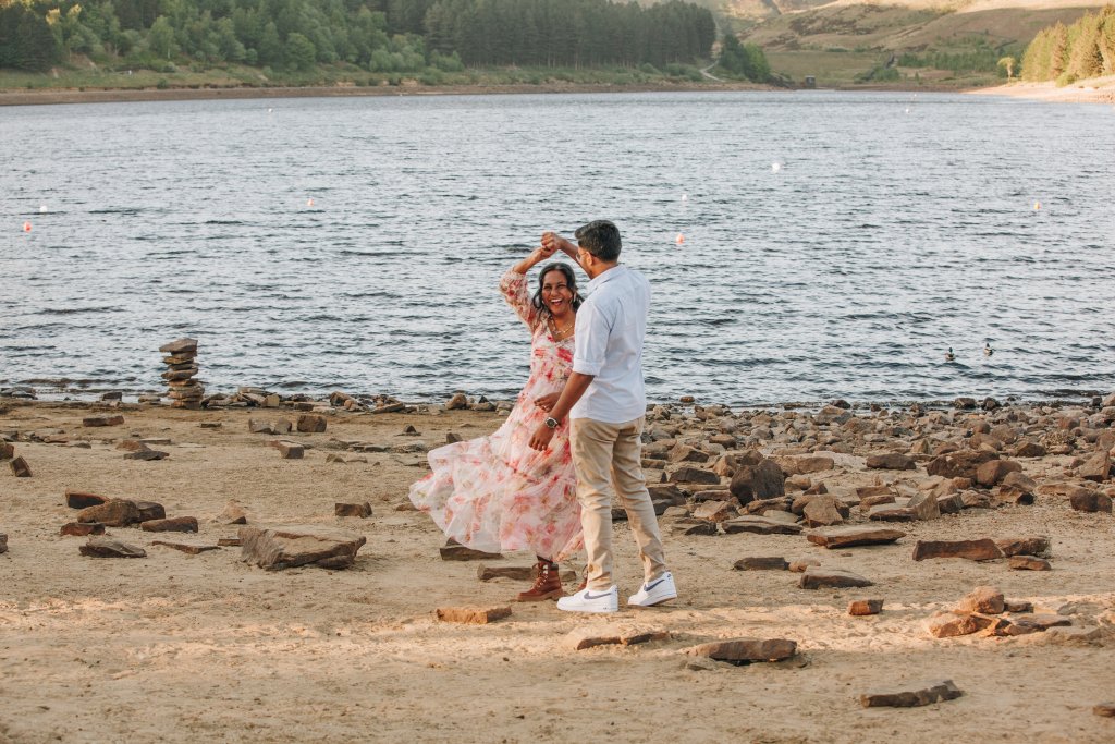 Engaged couple standing close dancing in peak district during a relaxed engagement shoot twilight