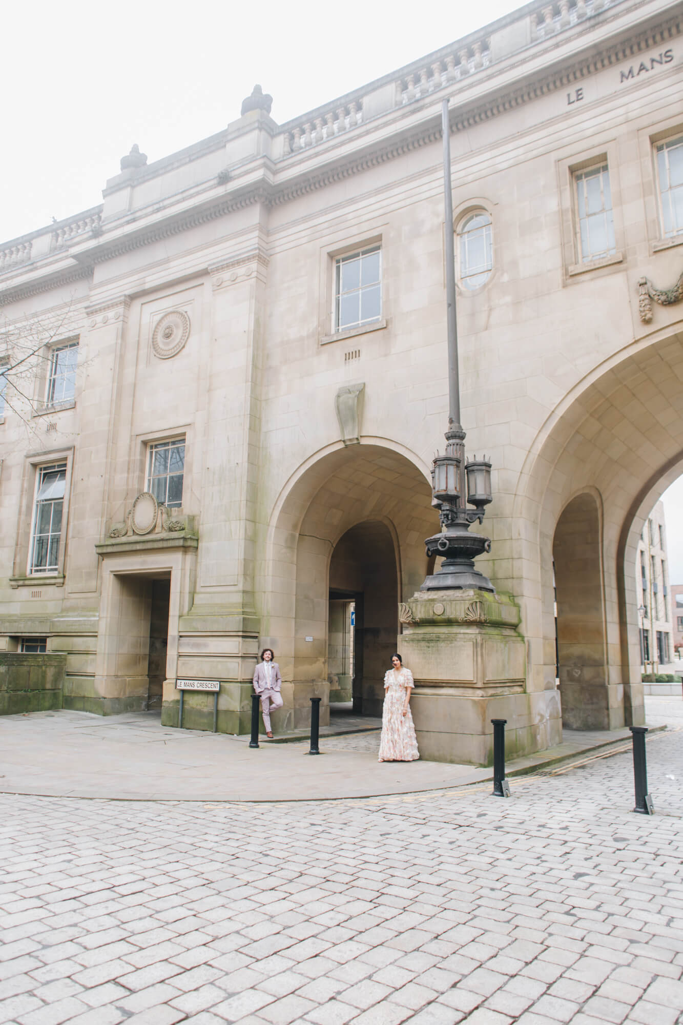 Bride and groom walking by Bolton Town Hall steps wedding photography Bolton