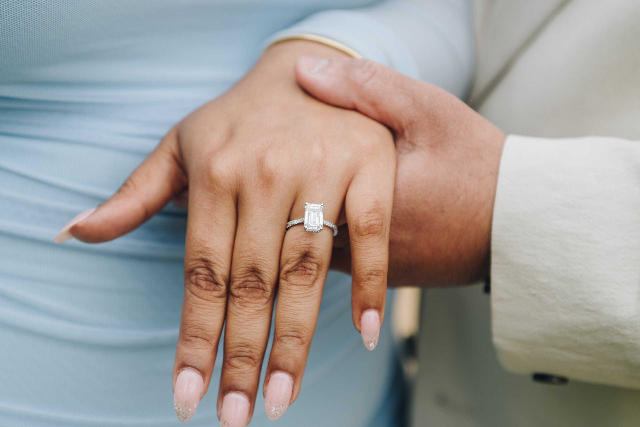 Hands of newly engaged couple with ring in Chatsworth House gardens