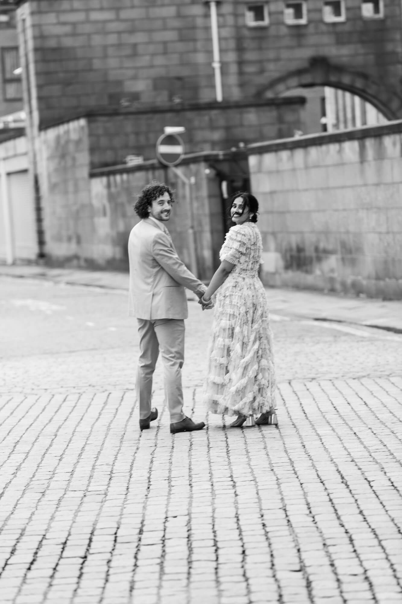 Couple walking through Bolton town centre after wedding ceremony