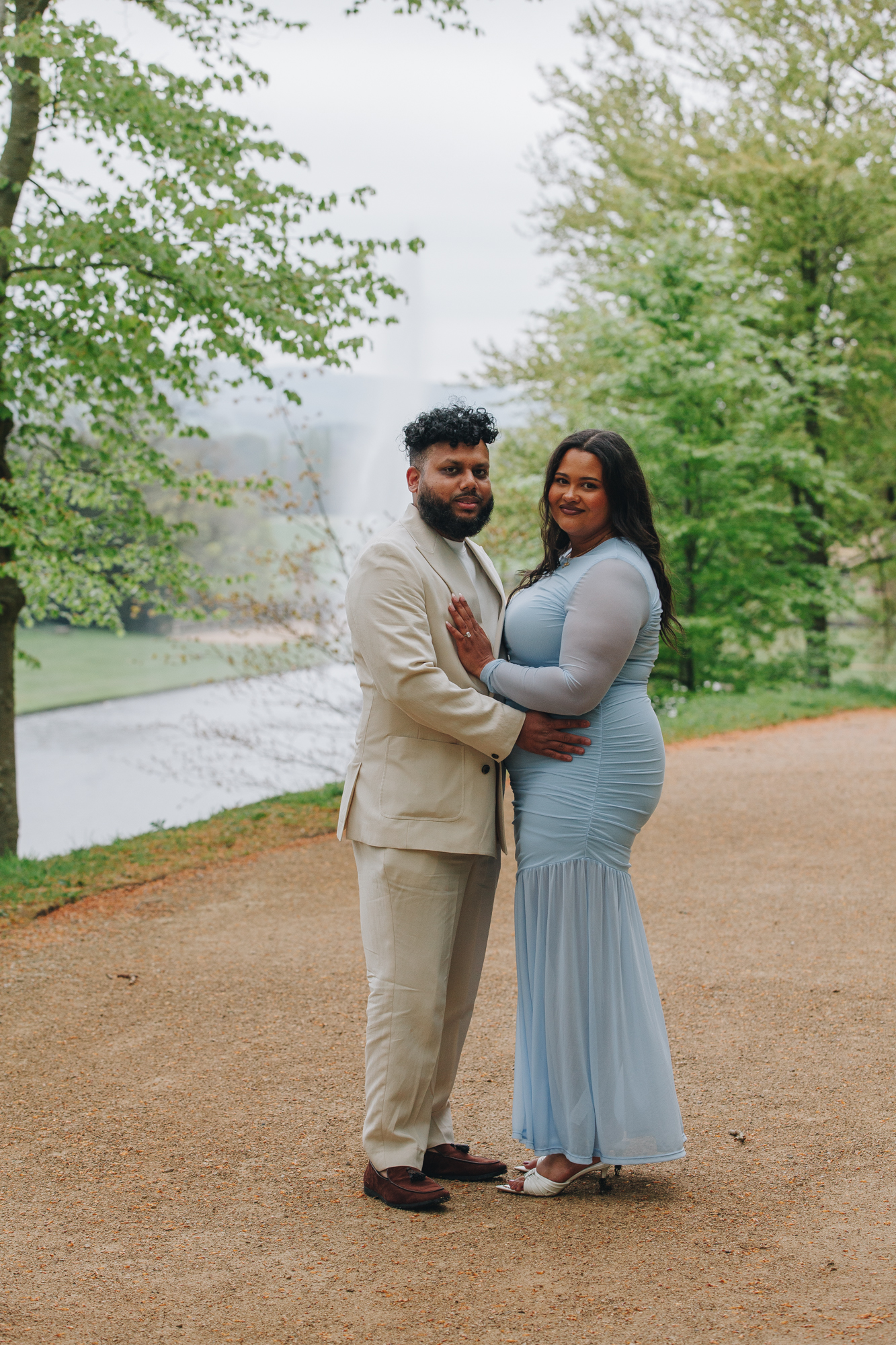 Engaged couple walking through spring gardens at Chatsworth House Derbyshire